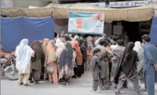  ?? APP ?? FAISALABAD
People standing in a queue waiting their turn outside Utility Store to buy flour at Government subsidized rates.