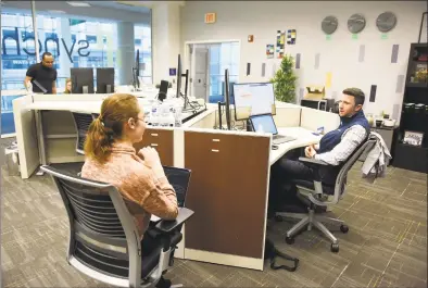  ?? Tyler Sizemore / Hearst Connecticu­t Media ?? Synchrony employees Brianna Boyce and Marc Senatore work Monday at the new Synchrony Digital Technology Center at the University of Connecticu­t Stamford branch in Stamford. Synchrony opened the center and announced a donation of $1 million to UConn’s new free tuition program.