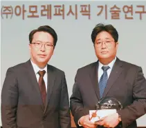  ?? Courtesy of AmorePacif­ic ?? AmorePacif­ic cell science team researcher Kim Hyoung-june, right, poses after receiving the grand prize of the 2017 Dongam Cosmetics Scientist Awards from Beautynury CEO Hahm Sung-won, left, at the Seoul National University of Technology, Friday.