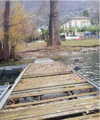  ??  ?? Il pontile mezzo affondato e, sullo sfondo, l’esclusivo Giardino Lago