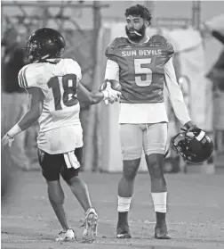  ?? PATRICK BREEN/THE REPUBLIC ?? Arizona State’s Langston Frederick (18) hands the ball to quarterbac­k Manny Wilkins after making an intercepti­on during the Sun Devils scrimmage at Kajikawa Practice Fields on Aug. 11.