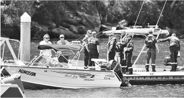  ??  ?? Australian Fire & Rescue personnel stand near their boats after visiting the scene where a seaplane crashed on Sunday killing six people, at Apple Tree Bay boat ramp located on the Hawkesbury River, north of Sydney, Australia. — Reuters photo