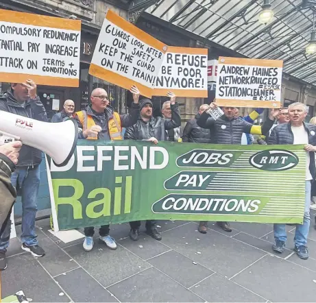  ?? ?? ↑ Striking rail workers from the RMT union outside Glasgow Central Station in September this year