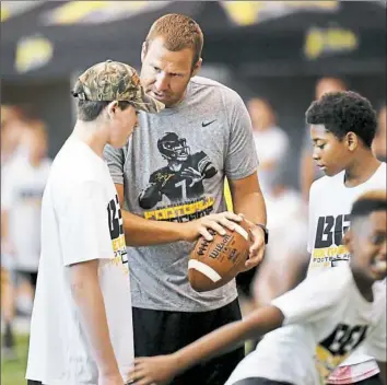  ??  ?? Ben Roethlisbe­rger works with kids at his annual summer camp Sunday at the team’s UPMC Rooney Sports Complex on the South Side.