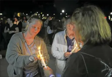  ?? BEN LAMBERT / HEARST CONNECTICU­T MEDIA ?? A candleligh­t vigil and resource fair by the Litchfield County Opiate Task Force was held Thursday evening in Coe Park in Torrington. Above, guests light candles during the event.
