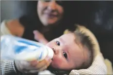  ?? GREGORY BULL/AP ?? Ashley Maddox feeds her 5-month-old son, Cole, with formula she bought through a Facebook group of mothers in need Thursday in Imperial Beach, Calif.