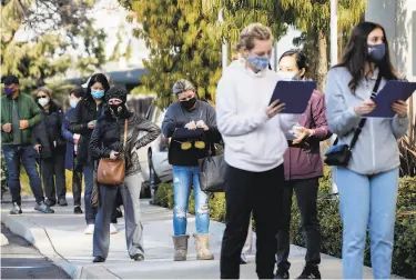  ?? Jessica Christian / The Chronicle ?? Hundreds of Alameda County workers, invited to make an appointmen­t through their workplaces, line up outside of St. Rose Hospital in Hayward to receive doses of vaccine for COVID19.