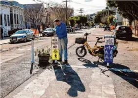  ?? Photos by Gabrielle Lurie/The Chronicle ?? As “mayor” of Slow Sanchez Street, Andrew Casteel monitors goings-on from his bicycle. His stewardshi­p includes beautifica­tion, cleanup and minor repairs.