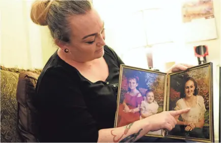  ?? DAN ANDERSON/AP ?? Amber Sawyer of Pascagoula, Miss., holds photos of herself, left, when she was 8 with her sister Angela at age 4 and her oldest sister, Donna, at 21. The photo was taken several months before Donna committed suicide in 1988.