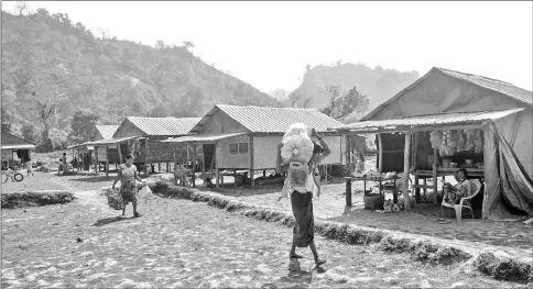  ??  ?? Photo shows Rakhine villagers carrying their belongings in Koe Tan Kauk village, Rathedaung township in Myanmar’s Rakhine State. — AFP photos