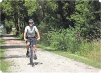  ?? COURTESY LAUREE RENAUD ?? Mike Rhoades rides along the Mascoutin Valley State Trail near Ripon.