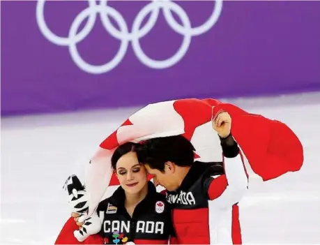  ??  ?? Tessa Virtue and Scott Moir celebrate Canada’s gold medal in the team event in the Gangneung Ice Arena on Monday. Virtue and Moir, as well as Meagan Duhamel, Eric Radford and Patrick Chan, are retiring from competitiv­e figure skating after the Games....