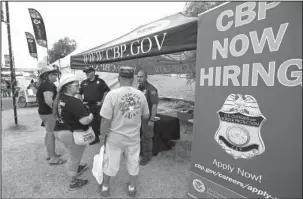  ?? The Associated Press ?? HELP WANTED: U.S. Border Patrol agents talk to visitors at a recruitmen­t tent set up April 9 at the Country Thunder Music Festival in Florence, Ariz. U.S. Customs and Border Protection, the parent agency of the Border Patrol and of Office of Field...