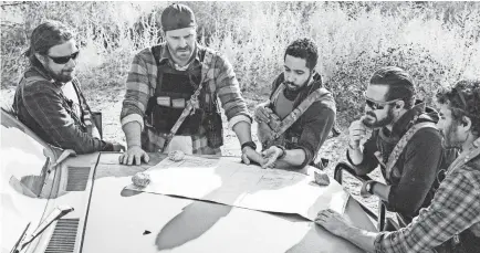  ??  ?? Tyler Grey, left, a “SEAL Team” consulting producer who also plays Trent, talks to cast members David Boreanaz, Neil Brown Jr., A.J. Buckley and Justin Melnick before filming a scene of the CBS military drama. ERIK VOAKE/CBS