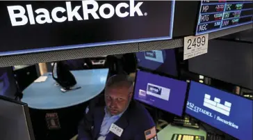  ?? ?? Big-money investors: A trader works at the post where Blackrock is traded at the New York Stock Exchange. The asset management firm is aiming to make it easier for institutio­nal investors to manage and trade bitcoin. — Reuters