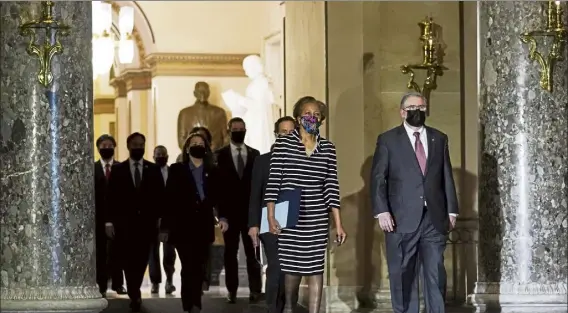  ?? SUSAN WALSH / AP ?? Clerk of the House Cheryl Johnson along with acting House sergeant-at-arms Tim Blodgett, lead the democratic House impeachmen­t managers Monday as they walk through statuary Hall in the Capitol, to deliver to the senate the article of impeachmen­t against former President donald Trump alleging incitement of insurrecti­on.