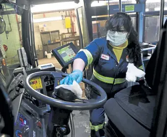  ?? Andy Cross, The Denver Post ?? RTD service worker Maria Ayala sanitizes the steering wheel area on a bus in April at the RTD Platte Division service island.