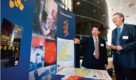  ??  ?? October 11, 2006: A Chinese expert and his EU counterpar­t talk in front of a billboard for the EU- China Science & Technology Year in Brussels, home to the headquarte­rs of the European Commission. Xinhua