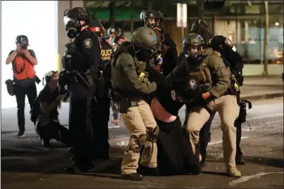  ?? The Associated Press ?? PORTLAND: Federal officers arrest a demonstrat­or during a Black Lives Matter protest Wednesday at the Mark O. Hatfield United States Courthouse in Portland, Ore.