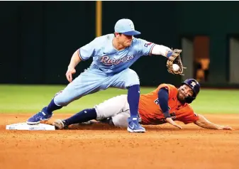  ?? AP Photo/Ray Carlin ?? ■ Texas Rangers second baseman Nick Solak, left, forces out Houston Astros’ Jose Altuve, right, at second base during the sixth inning Sunday in Arlington, Texas.