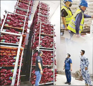  ?? MIGUEL DE GUZMAN ?? Members of the Bureau of Customs’ Customs Intelligen­ce and Investigat­ion Service, Philippine Coast Guard and the Criminal Investigat­ion and Detection Group inspect sacks of suspected smuggled onions and garlic valued at P95 million in a cold storage facility in Catmon, Malabon on Friday night. Inset shows BOC personnel checking sacks of sugar during an operation at the Manila Internatio­nal Container Port on Friday.