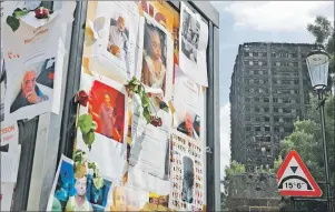  ?? "1 1)050 ?? Pictures of missing people on a message board near to the burnt Grenfell Tower apartment building standing testament to the recent fire in London Friday.