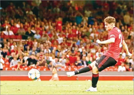  ?? GEOFF CADDICK/AFP ?? Manchester United’s Daniel James scores the winning penalty during the 2019 Internatio­nal Champions Cup match against AC Milan at the Principali­ty Stadium, Cardiff on Saturday. United beat Milan 5-4 on penalties.