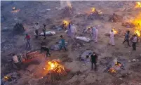  ?? (Danish Siddiqui/Reuters) ?? PEOPLE WAIT at a crematoriu­m ground in New Delhi on Friday to cremate victims who died from coronaviru­s.