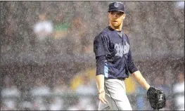  ?? NWA Democrat-Gazette/ANDY SHUPE ?? Corpus Christi pitcher Collin McHugh heads to the dugout in heavy rain Friday after being removed from the game against the Naturals at Arvest Ballpark in Springdale.