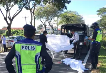  ??  ?? Police personnel prepare to transport the body to the hospital.