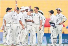  ?? AFP ?? Trent Boult (centre) celebrates with teammates after removing Asad Shafiq on the second day of the first Test between Pakistan and New Zealand in Abu Dhabi on Saturday.