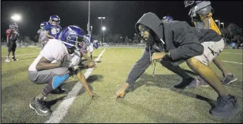  ?? Richard Brian Las Vegas Review-Journal @vegasphoto­graph ?? Warriors lineman Jordan Jackson, 7, gets help on his stance from assistant coach Craig Davis during practice Thursday. The program pursues sponsorshi­ps and hosts several fundraiser­s throughout the year to minimize the costs for participan­ts.