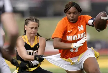  ?? Associated Press photos ?? Ottawa defensive end Jennifer Anthony, left, tackles Midland’s JaNasia Spand in a recent women’s flag football game in Ottawa, Kan. Women’s flag football is an emerging sport in the NAIA.