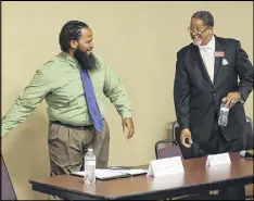  ?? CURTIS COMPTON / CCOMPTON@AJC.COM ?? Mayoral candidates Douglas Favors (left) and Jason Lary arrive next to an empty chair for Charles Hill for their debate at Salem Bible Church on Tuesday in Lithonia. Charles Hill, who is also running for mayor, was not present.