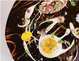  ?? ADORNED PHOTOGRAPH­Y ?? The new Fiola in Coral Gables crafts bison tartare with radicchio, maitake mushrooms and Parmigiano crema — one of its many artistic presentati­ons.