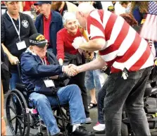  ?? NWA Democrat-Gazette/MIKE ECKELS ?? A World War II veteran receives a handshake from a well-wisher during the 2017 O&A Honor Flight welcome-home ceremony April 19 at Northwest Arkansas Regional Airport. Seventy-five military veterans from World War II, Korea and Vietnam, along with their...