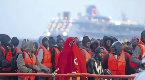  ?? Foto: Álex Zea/dpa ?? Sie haben die Überfahrt zumindest überlebt: Immigrante­n im Hafen von Málaga.