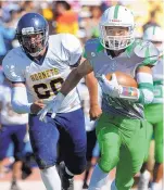  ?? JIM THOMPSON/JOURNAL ?? Albuquerqu­e High’s Alex Ortiz gets upfield for yardage as Highland defenders give chase. Ortiz ran for a touchdown during the Bulldogs’ 41-31 victory at Milne Stadium.