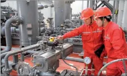  ?? HU QIMING / FOR CHINA DAILY ?? China Petrochemi­cal Corp employees at a natural gas storage plant in Puyang, Henan province.