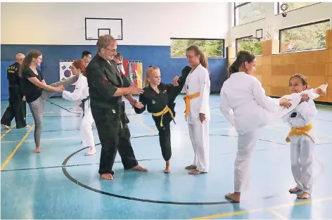  ?? RP-FOTO: RUTH KLAPPROTH ?? Beim Training: Dieter Bransch (vorne, auch der Vorsitzend­e des Vereins) und Klaus Blaschke (hinten links) und weitere Jugendtrai­ner üben mit Vereinsmit­gliedern. Hier geht es um Dehnübunge­n.