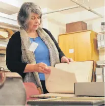  ?? DANIEL BROWN/THE GUARDIAN ?? Archivist Laura Millar flips through a preserved service register in the St. Peter’s Cathedral archive on Nov. 29. The register contains cathedral records between the years 1893 and 1900.