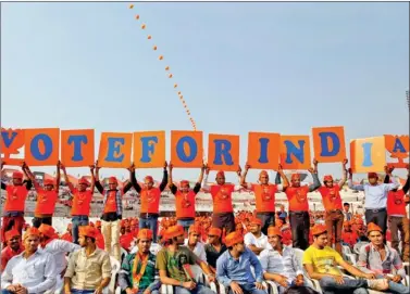  ?? REUTERS ?? Narendra Modi supporters hold placards at his rally in Ahmedabad on Thursday.