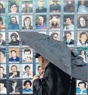  ?? Yuri Kadobnov AFP/Getty Images ?? IN 2012, a passerby in Moscow looks at the faces of some of those killed at the Dubrovka Theater in 2002.