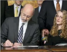  ?? MARC LEVY - THE ASSOCIATED PRESS ?? Pennsylvan­ia Gov. Tom Wolf of Pennsylvan­ia signs antihazing legislatio­n inspired by Penn State student Tim Piazza who died after a night of drinking in a fraternity house, Friday in Harrisburg. Sitting next to Wolf is Evelyn Piazza, the mother of Tim Piazza.