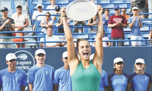  ?? Catherine Avalone / Hearst Connecticu­t Media ?? Aryna Sabalenka raises the trophy above her head to celebrate her victory over Carla Suarez Navarro in the Connecticu­t Open final on Saturday.