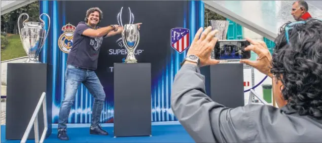  ??  ?? FOTO Y FOTO. La Plaza de la Libertad acogió un stand con la Champions, Europa League y Supercopa. Los 3.000 madrileños en la ciudad no dejaron de tocarlos, tomarles fotos.