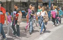  ??  ?? Inmigrante­s caminan desde una estación de autobús a un albergue de Catholic Charities, tras ser liberados de un centro migratorio, en McAllen.