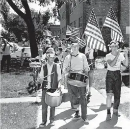  ?? LEONARD BARTHOLOME­W/CHICAGO TRIBUNE ?? At right, Mark Presmyk, 10, from left, Peter Kroll, 13, and Donald Luptak, 12, lead the children’s Fourth of July Parade on Byron Street in Chicago, from Central Avenue to Austin Avenue, on the holiday in 1964.