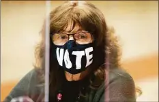  ?? Christian Abraham / Hearst Connecticu­t Media ?? Poll worker Marianne Lasalandra wears a VOTE mask while at the polling station inside Stamford High School in Stamford on November 2, 2021.