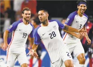  ?? Jeffrey McWhorter / Associated Press ?? Clint Dempsey (28) celebrates with teammates Graham Zusi (left) and Omar Gonzalez after scoring a goal against Costa Rica in a Gold Cup semifinal victory for the United States on Saturday.